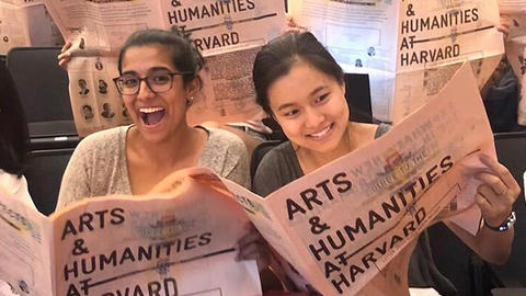 students looking over arts and humanities bulletin