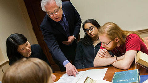 professor pointing something out to a group of students