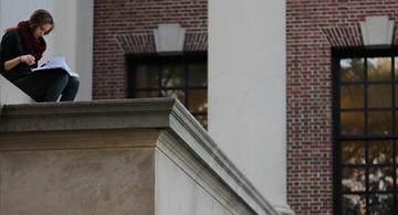 student reading on steps of Widener Library