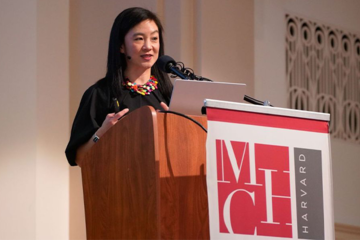 Hahrie Han, standing behind a podium with the MHC logo in front of it